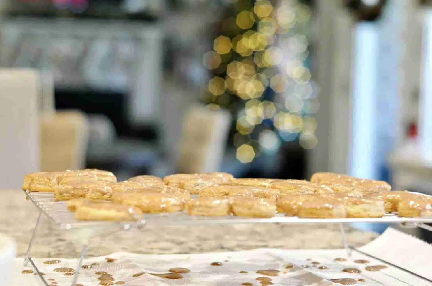 cookies cooling on a baking rack, with christmas tree in background.
