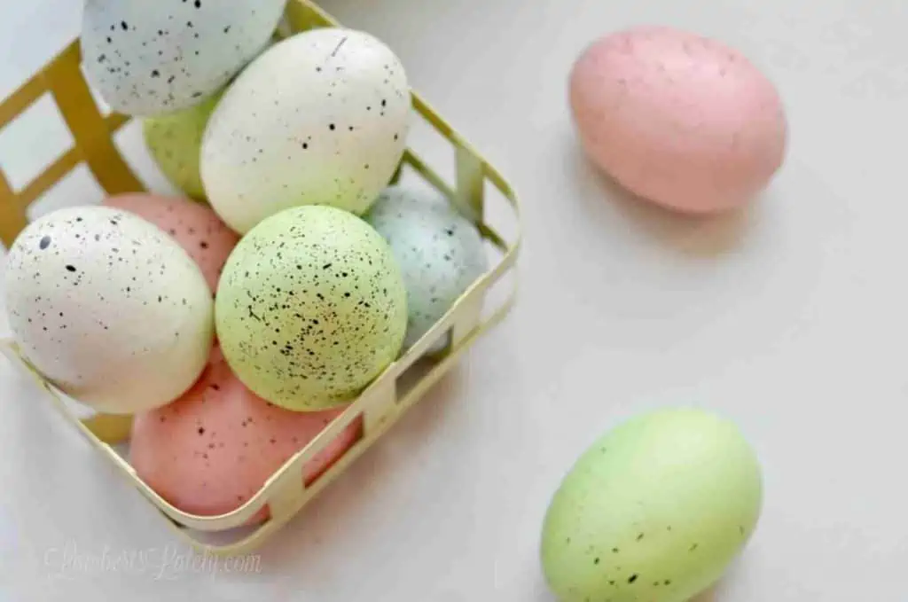 looking down on colorful eggs in a yellow basket.