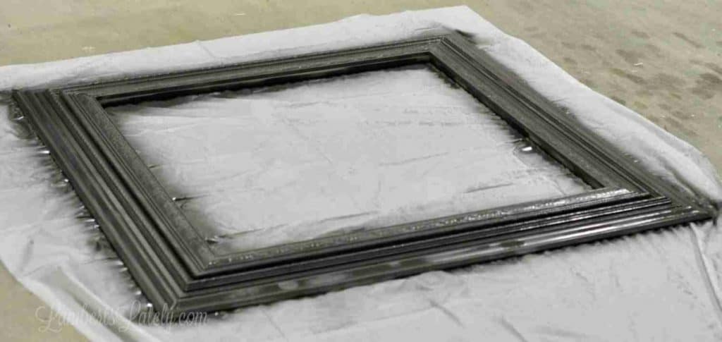 frame after being painted black, on a tarp.