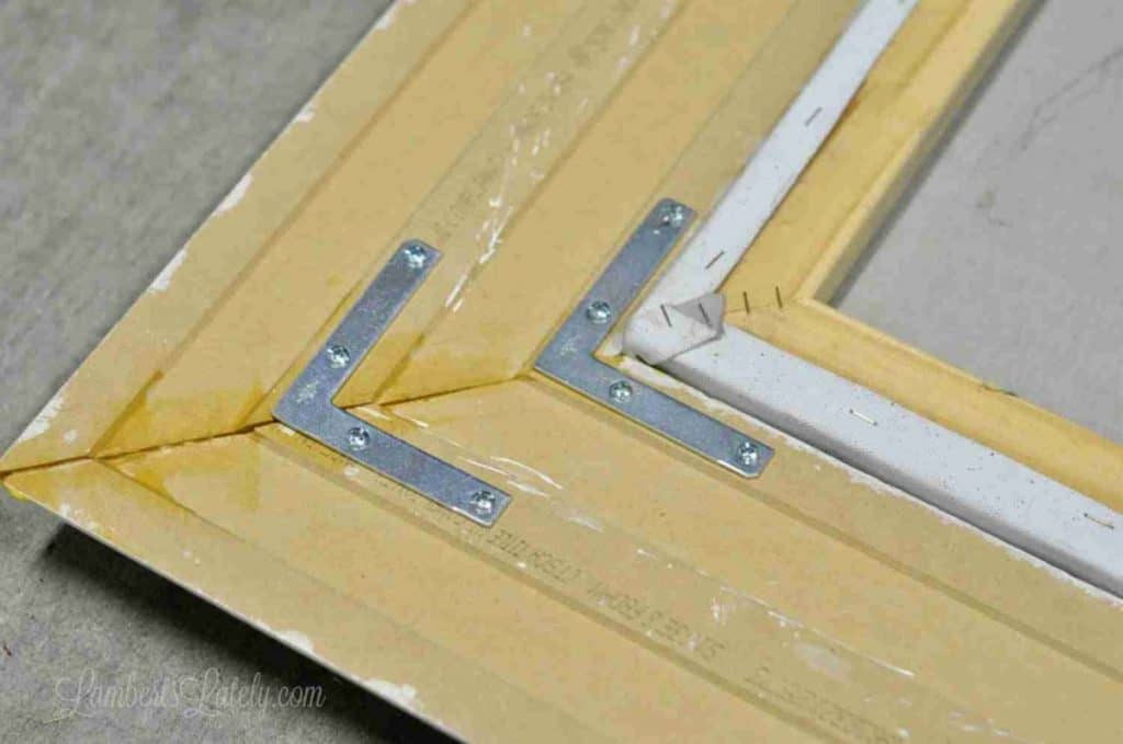 two metal brackets placed in corner of back of frame.