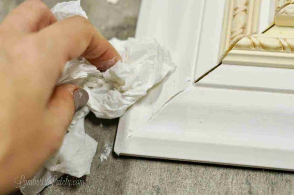 wiping caulk out of the corner of a frame.
