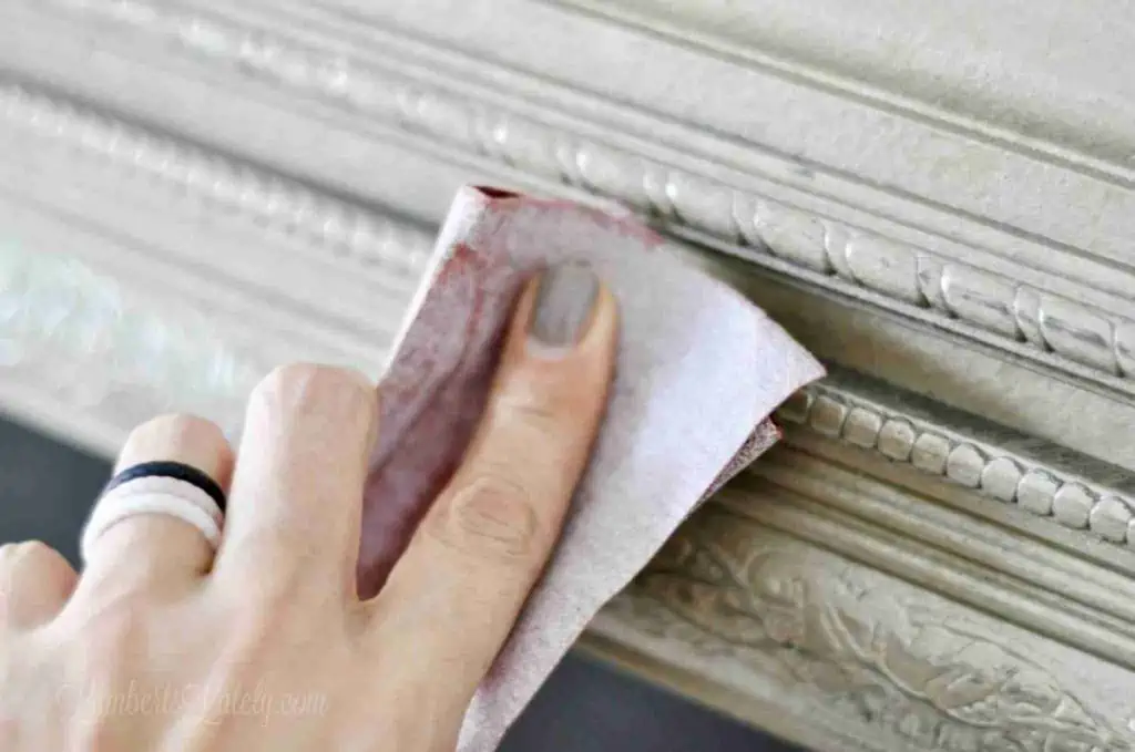 sanding the side of a gold picture frame.