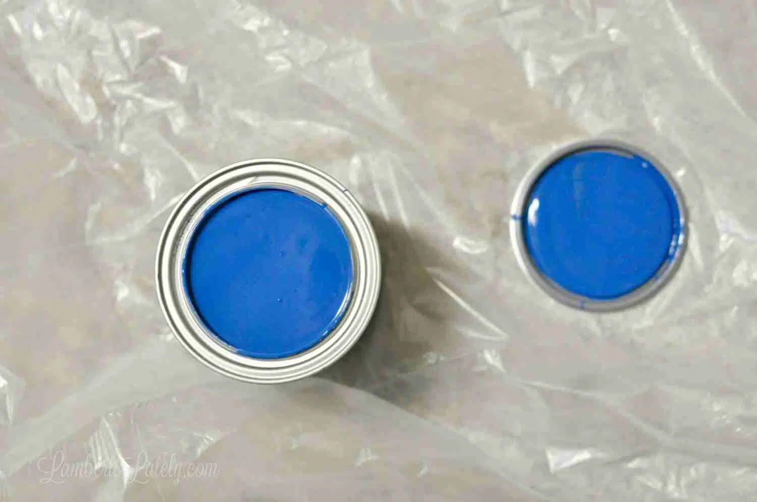 looking down on can of blue paint on drop cloth.