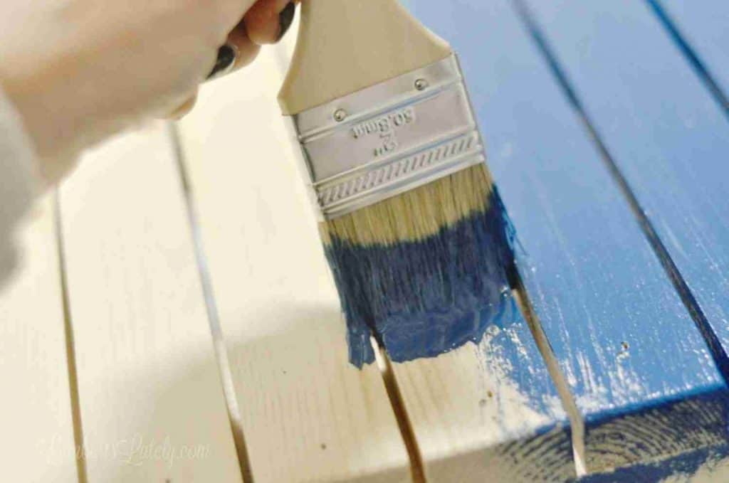 painting slats of a table blue.