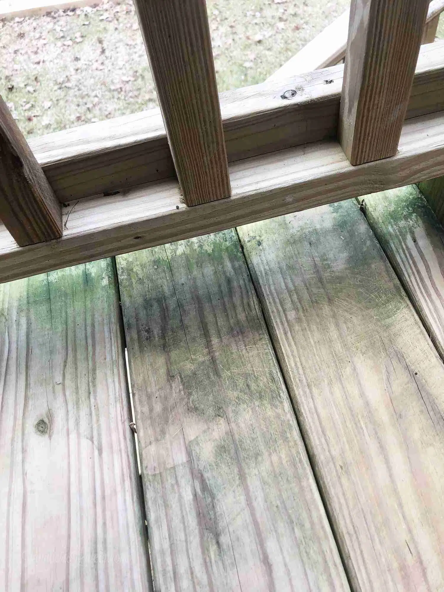 green stains under railing on a deck after scrubbing.