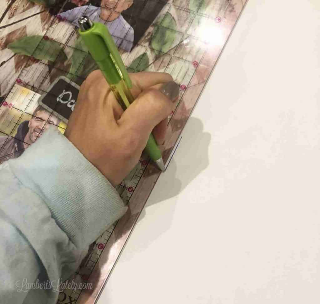 tracing outline of a frame onto fabric with a pen.
