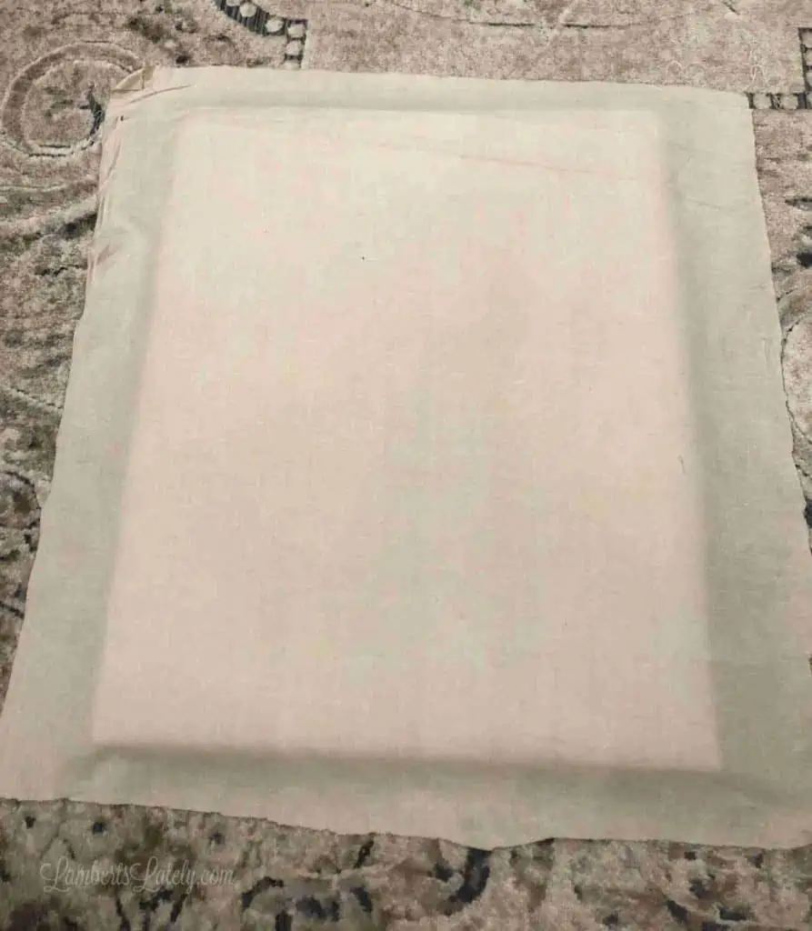 brown fabric laid out under the back of a frame.