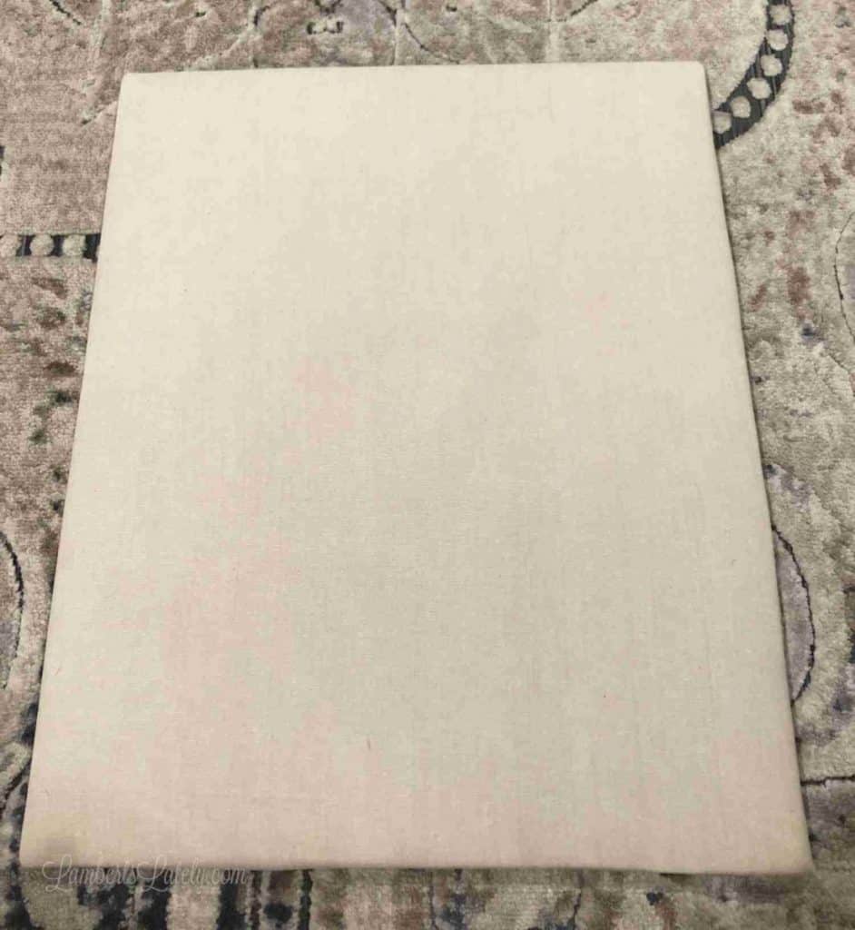 brown cloth wrapping the back piece of a shadow box.