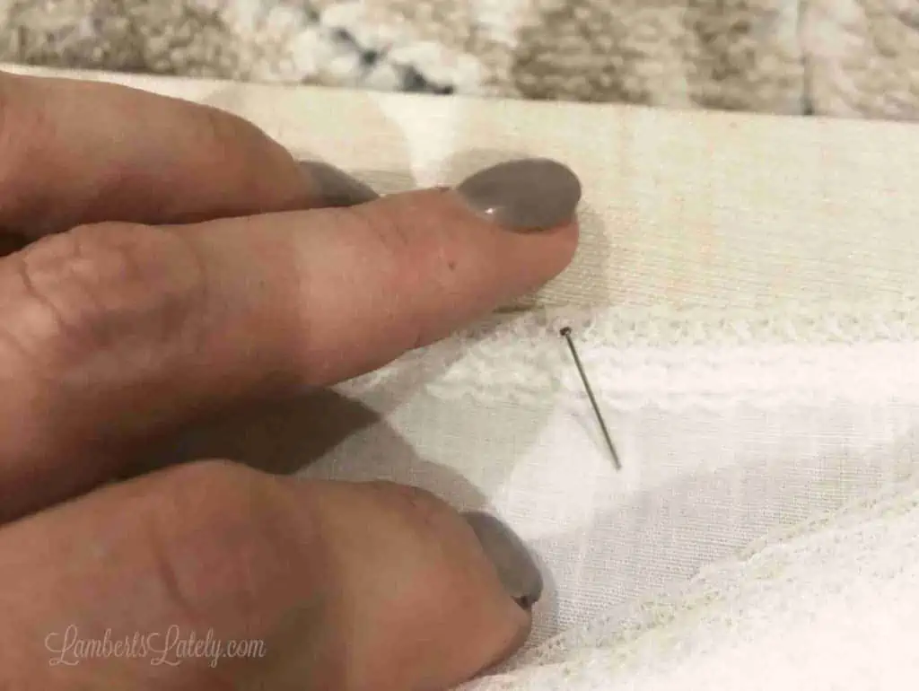pushing a pin into fabric.