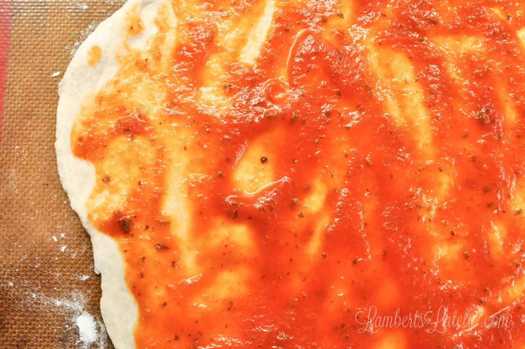 tomato sauce spread on pizza dough.