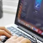 Person cleaning a MacBook with a focus on keeping it organized and efficient.