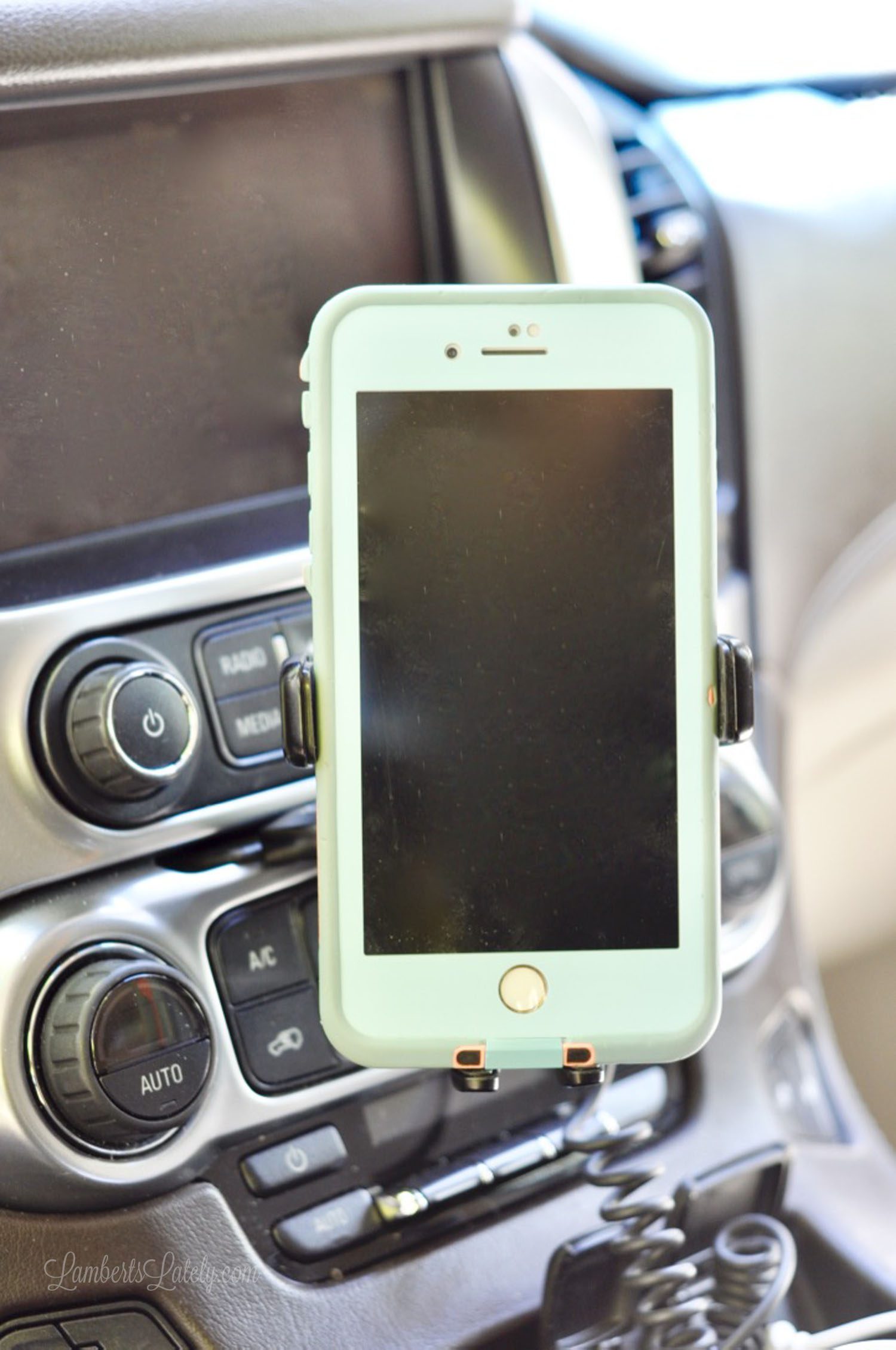 blue iPhone on a holder in a car.