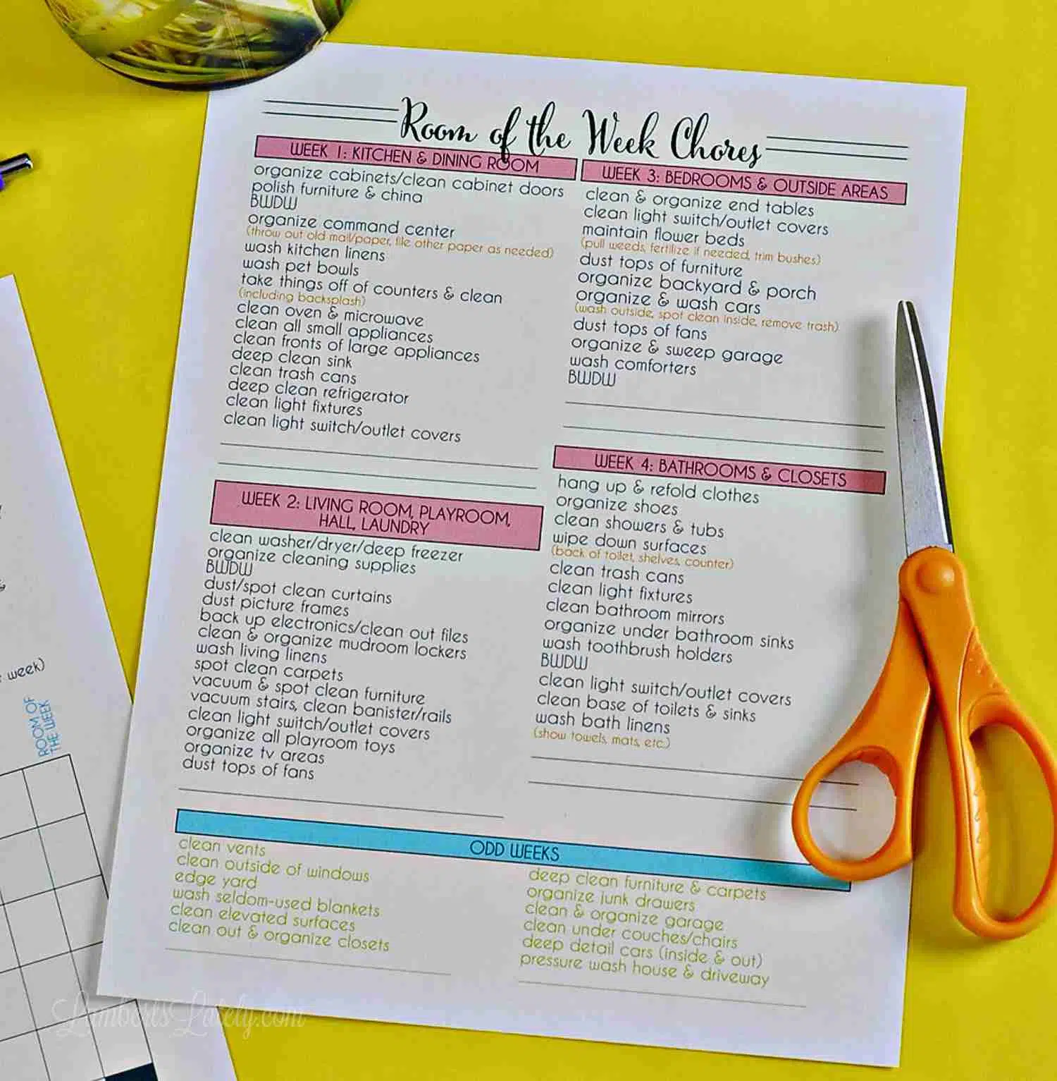 room of the week cleaning checklist on a yellow background with a pair of scissors.