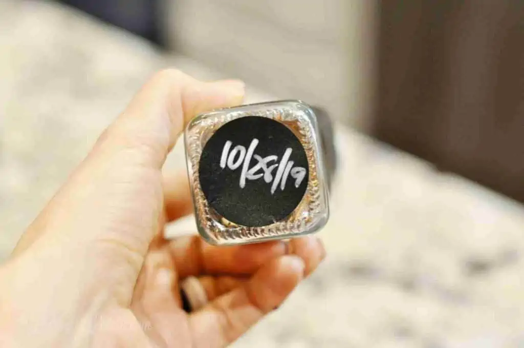 black label on bottom of glass spice jar with date written in silver paint pen.