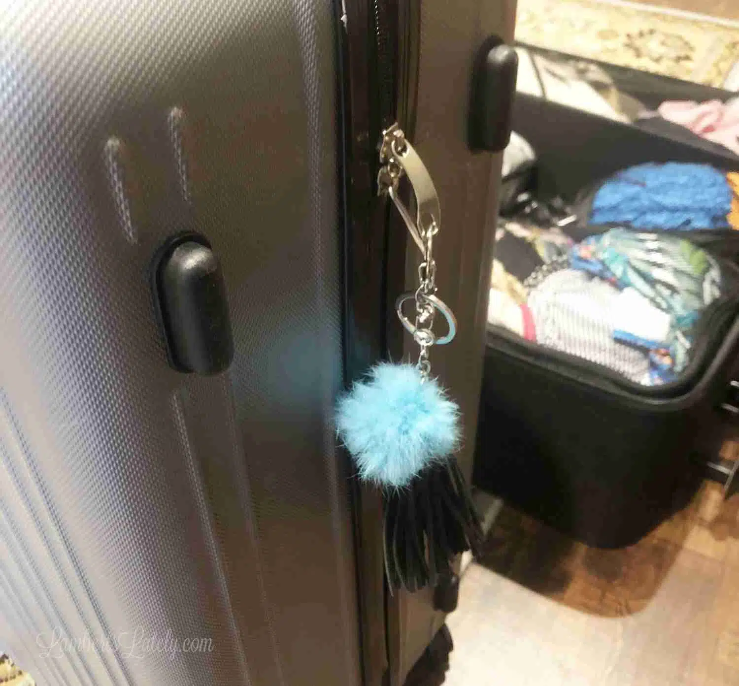 puffy blue keychain on a suitcase.