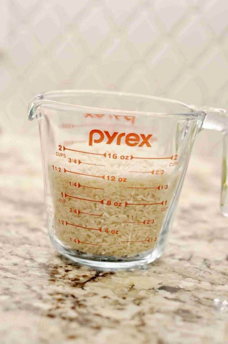 rice in a pyrex measuring cup on a counter.