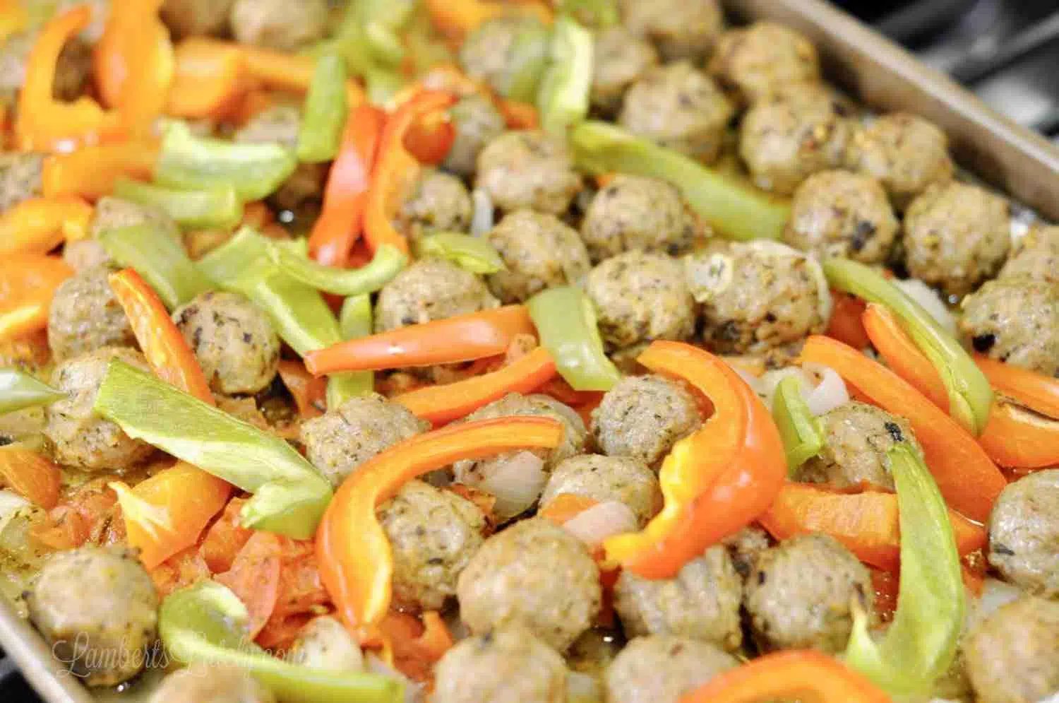 meatballs and peppers on a sheet pan.