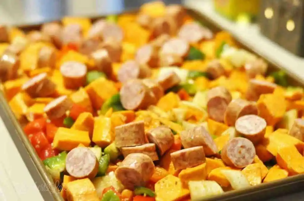 sausage, sweet potatoes, peppers, and onions on a sheet pan after baking.