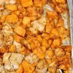 Sheet pan with BBQ chicken and sweet potatoes for easy freezer meal prep.