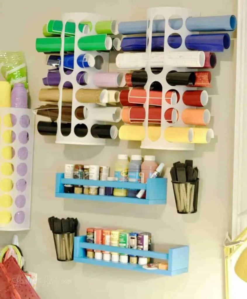 cutting vinyl in a plastic organizer hung on a wall.