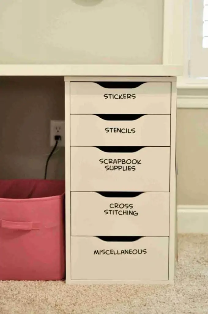 labeled shelves of a desk in a craft room.