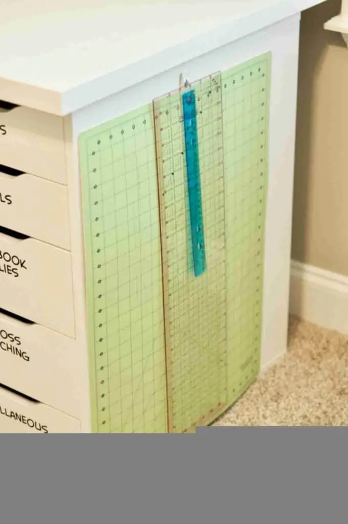 cutting mat and ruler hanging on the side of a desk.