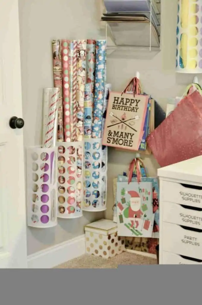 gift wrapping paper organized in holders on a wall.