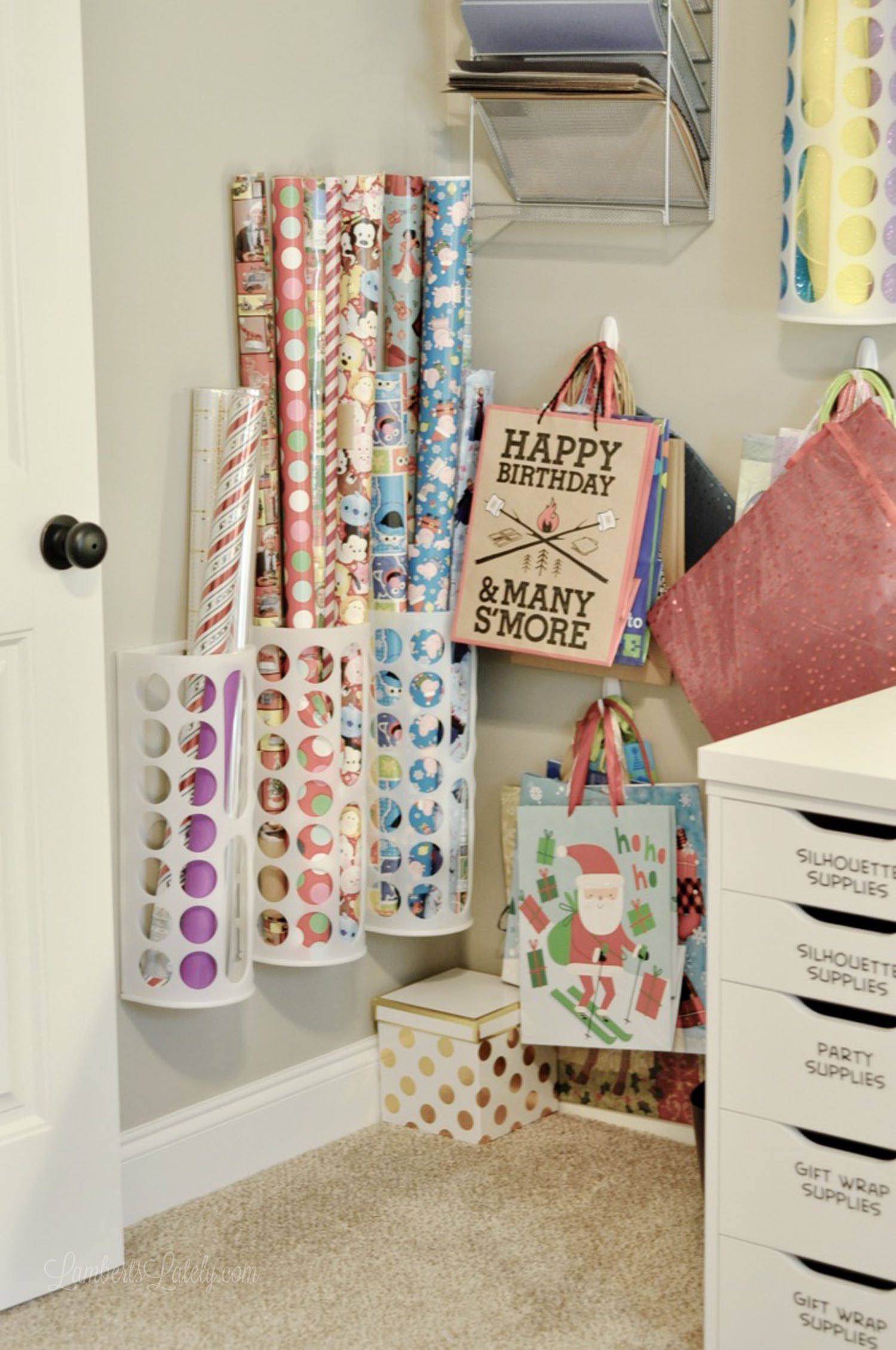 gift wrapping paper organized in holders on a wall.