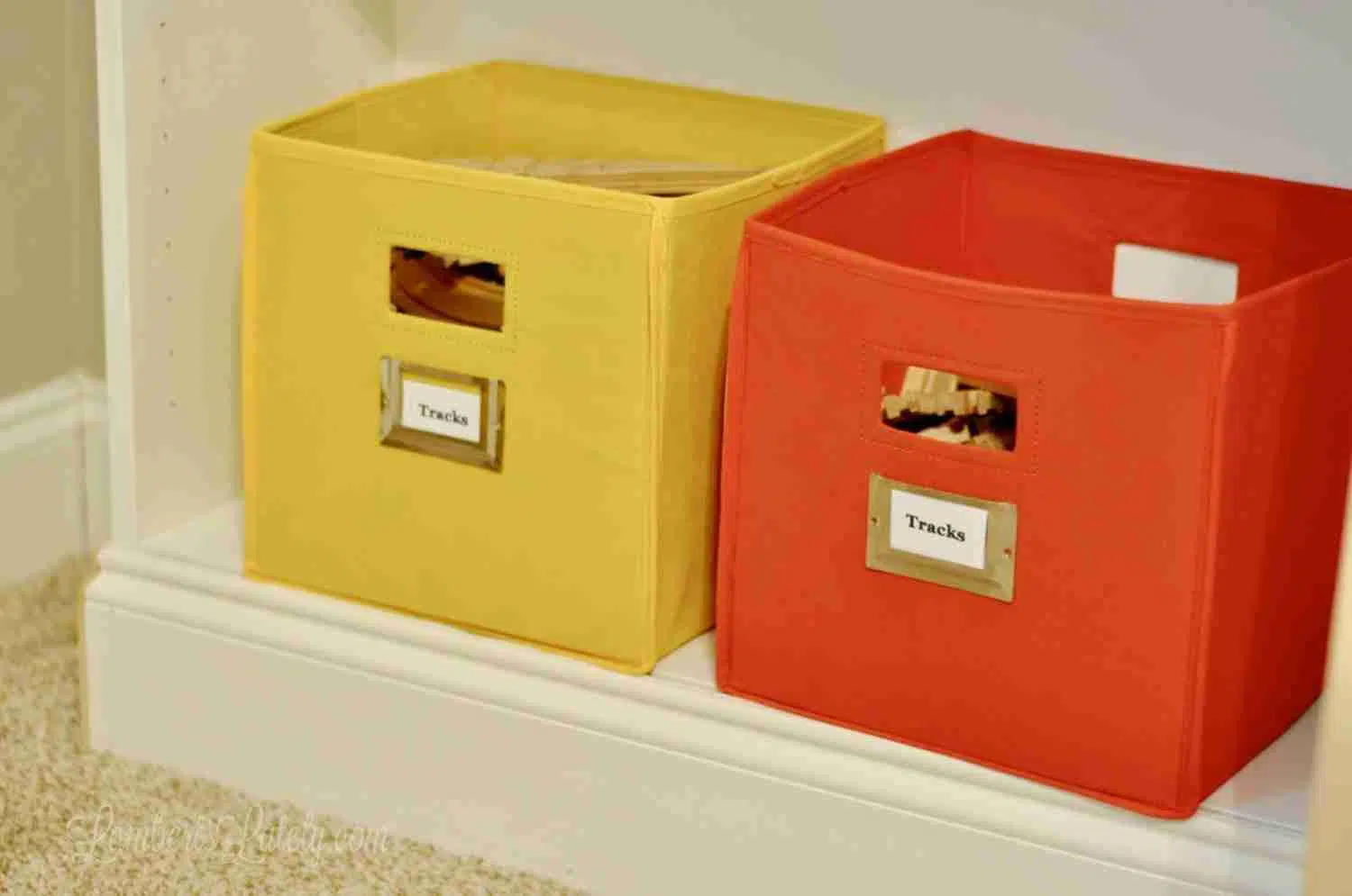 yellow and red fabric bins on a white shelf.