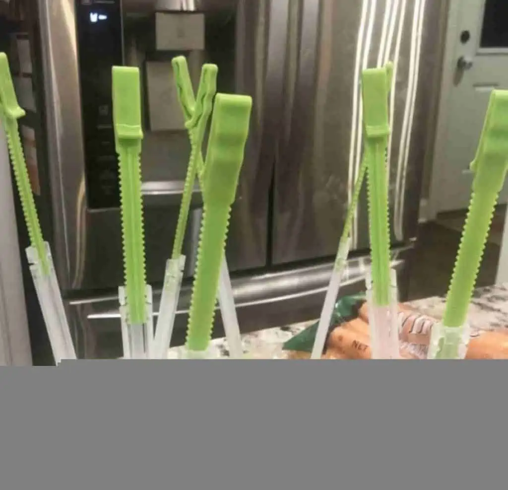 green plastic bag openers on a counter.