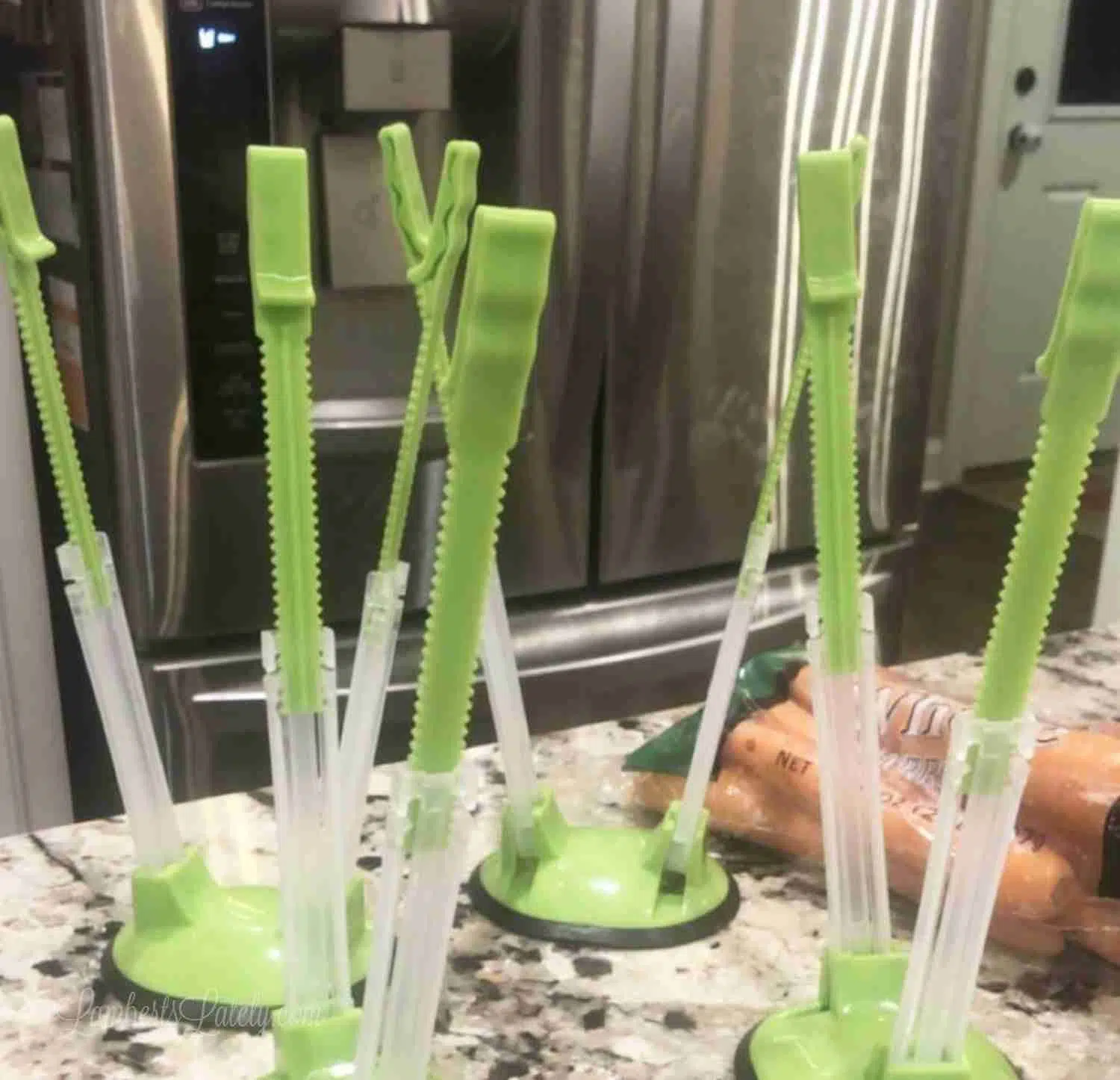 green plastic bag openers on a counter.