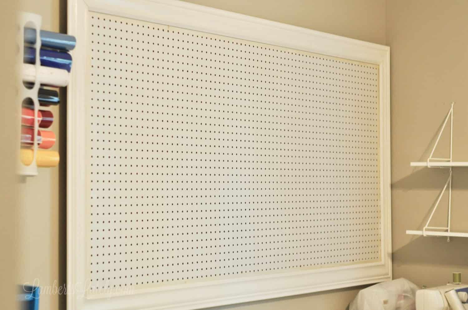 empty white pegboard in craft room.