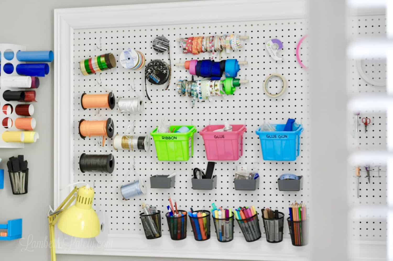 large white pegboard with colorful craft supplies.
