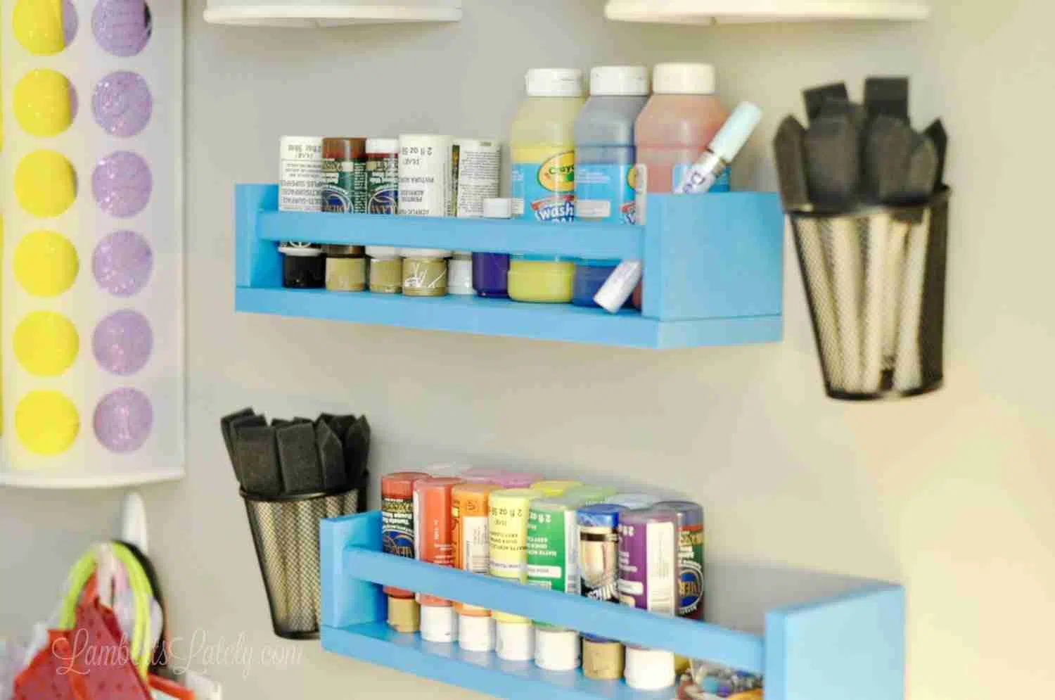 blue wooden shelves hanging on a wall, holding paint jars