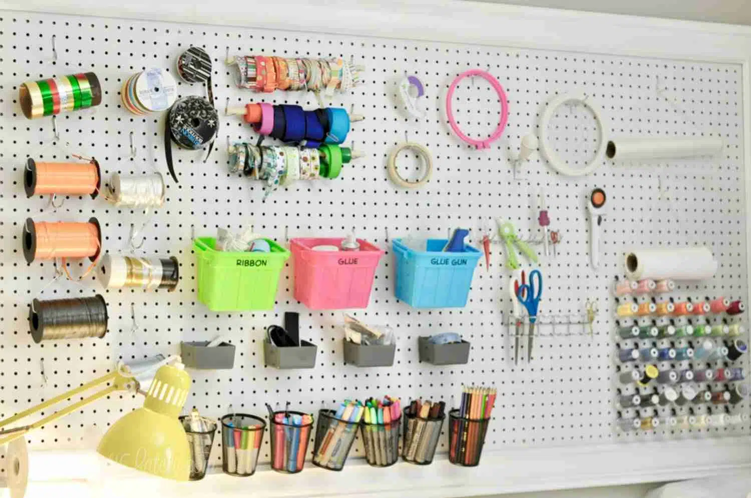 craft room peg board with various organized craft supplies