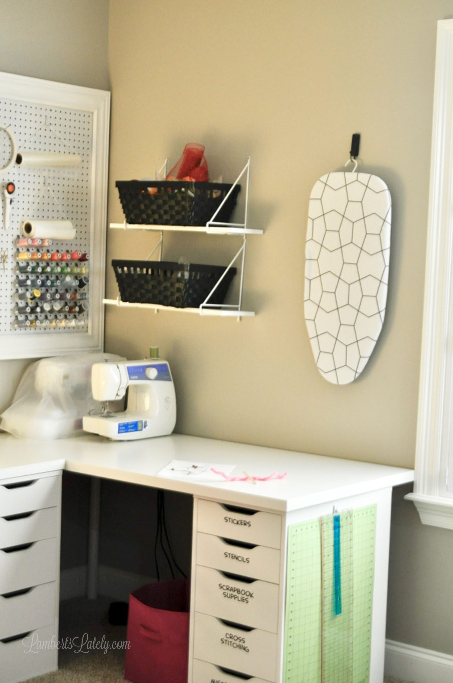 craft room desk, with baskets and a mini ironing board hanging above