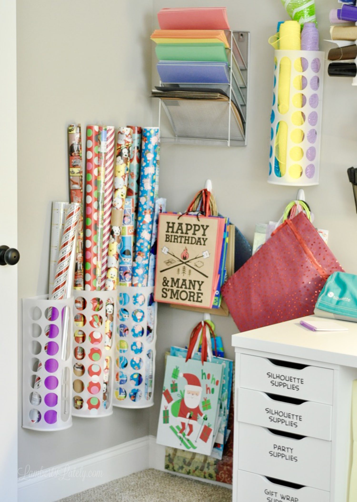 gift wrapping supplies hanging on a wall in a craft room