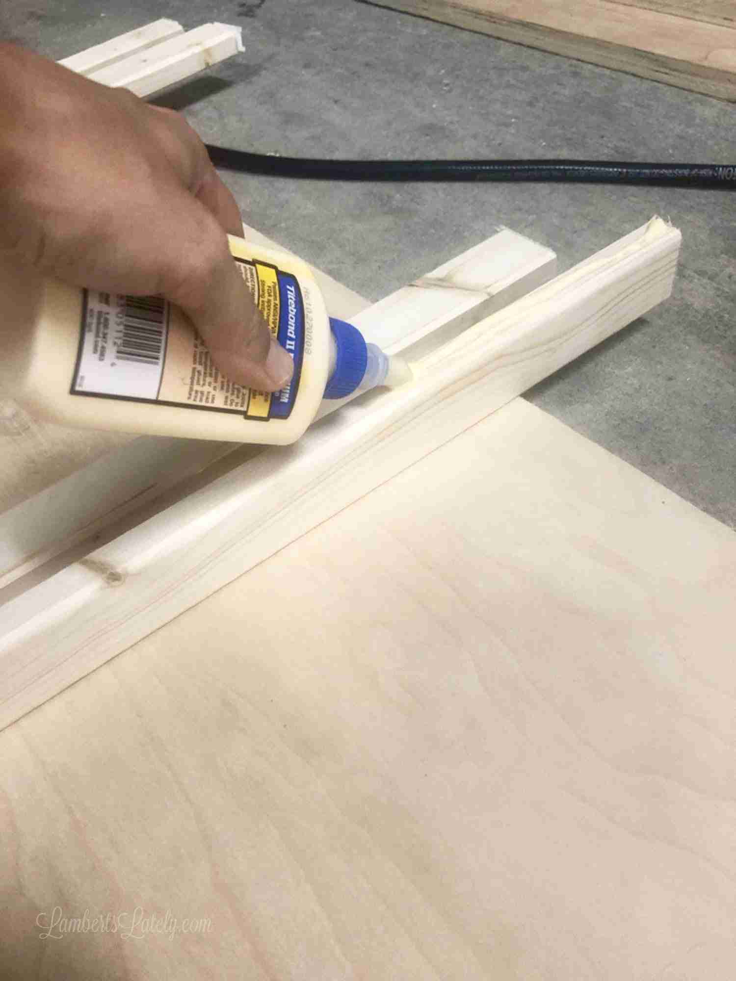 adding wood glue to a 1x2" piece of wood.