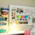 Organized craft room with pegboard, storage bins, and crafting supplies on a budget.