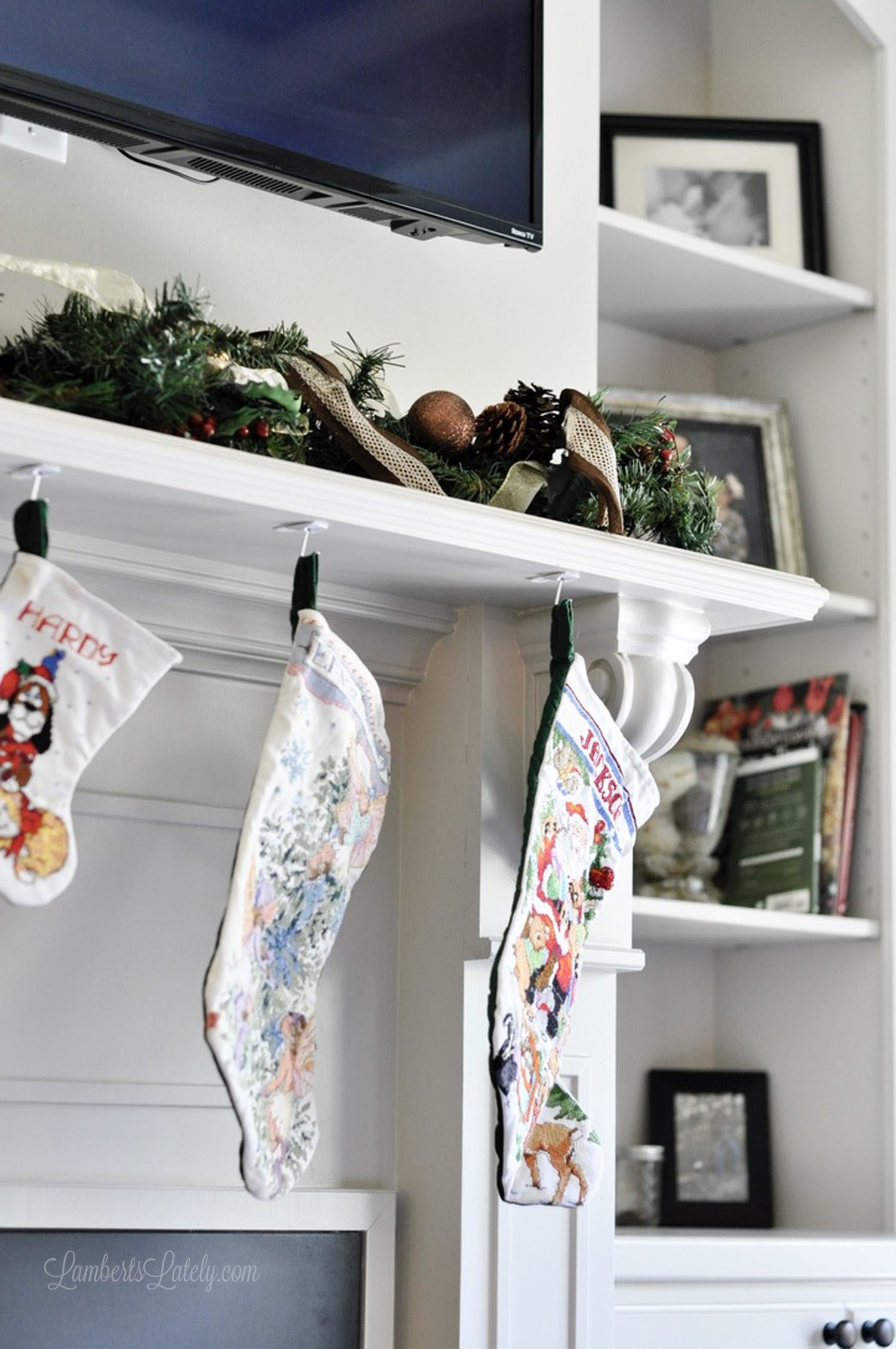 Long picture of stockings hung on a mantle with Christmas decorations