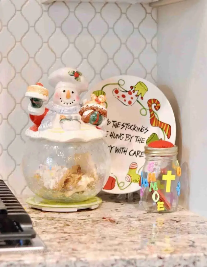 snowman cookie jar and christmas plate on a counter.