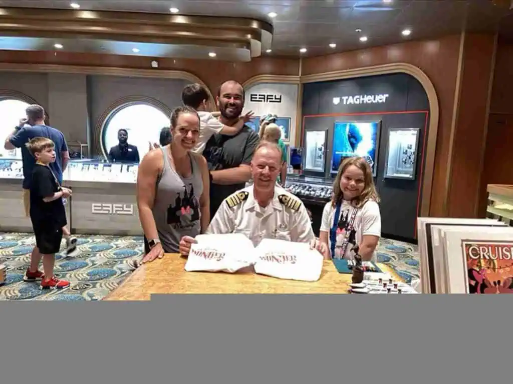 captain signing autographs on Disney Wonder.
