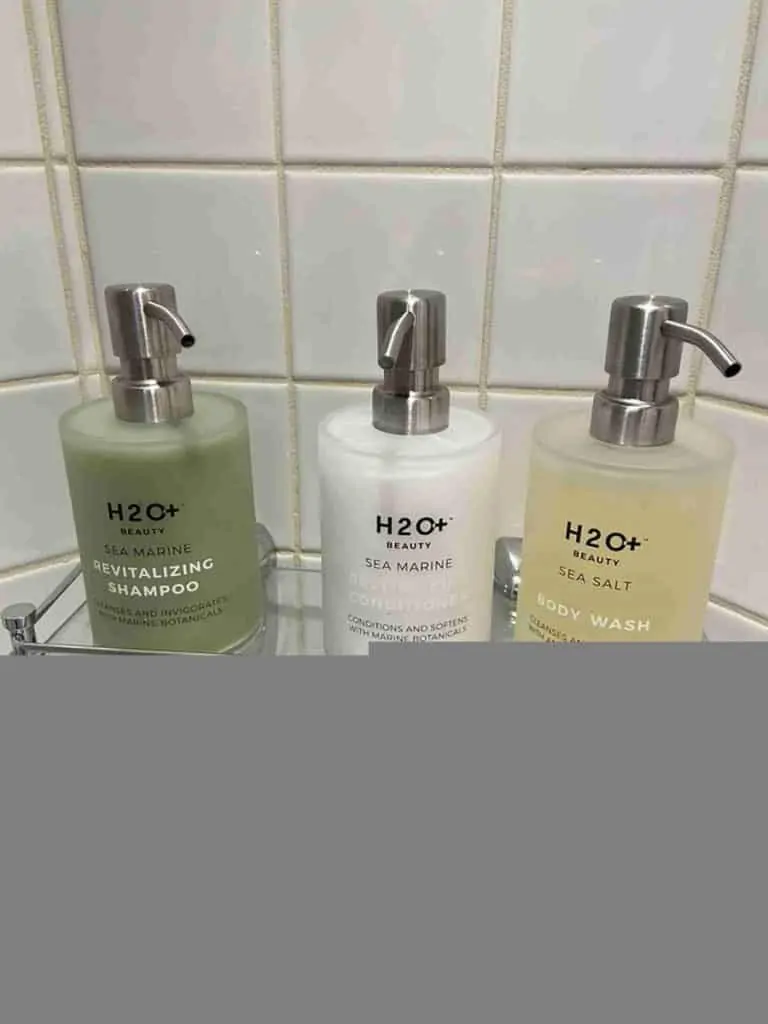 h20 shampoo, conditioner, body wash in a shower on a disney cruise.