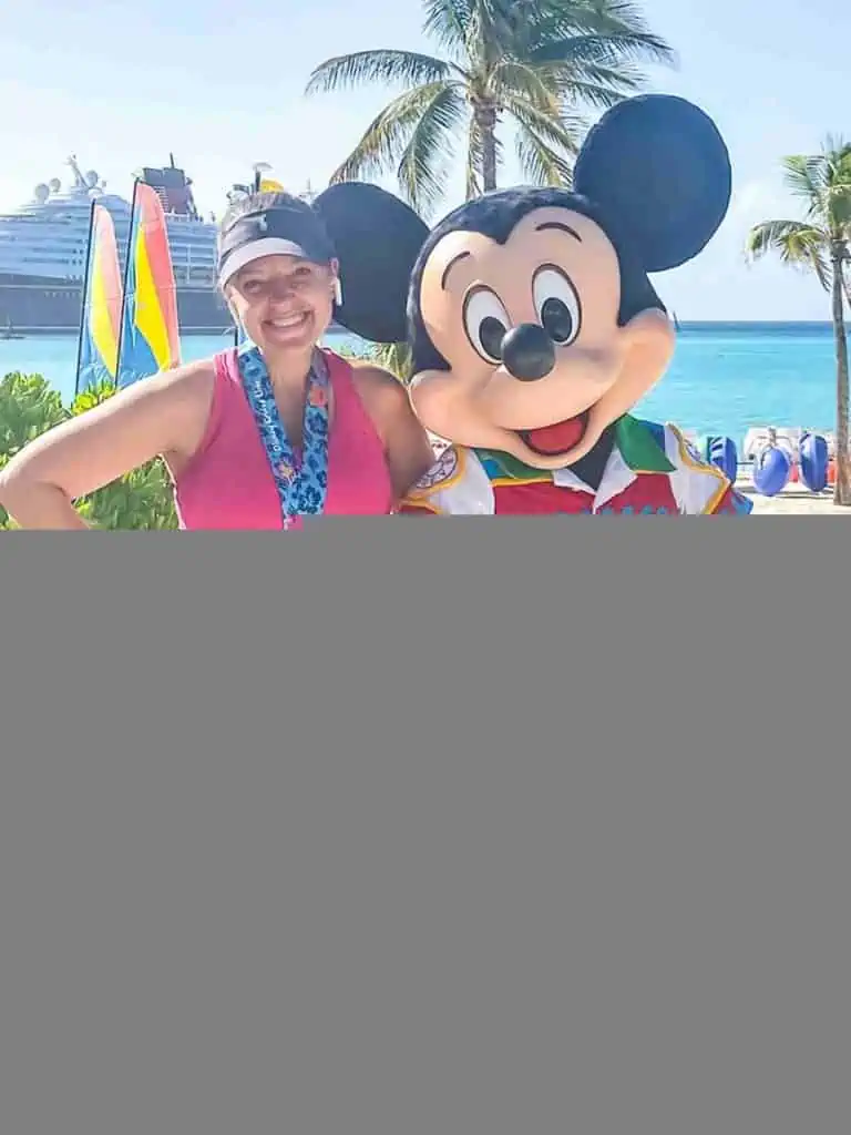 With Mickey Mouse after Castaway Cay 5k, with Disney wonder in the background.