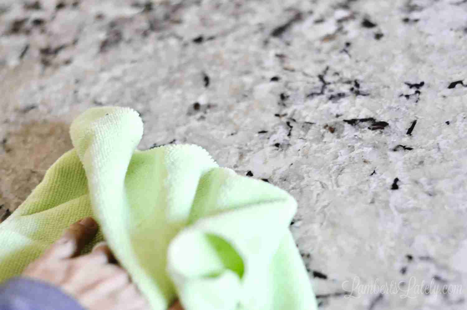 wiping Alaska white granite with a microfiber cloth