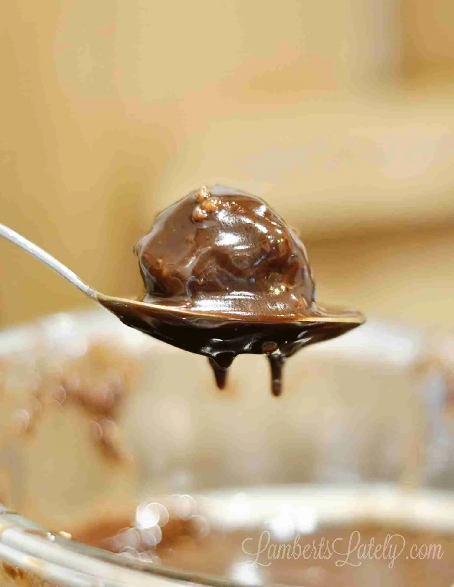 brownie bomb covered in melted chocolate in a spoon