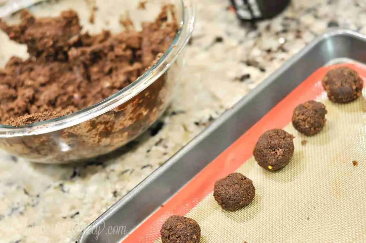 rolled brownie balls placed on a cookie sheet
