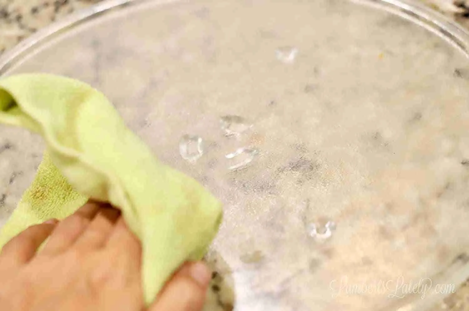 cleaning the turntable of a microwave with microfiber cloth