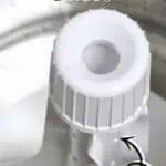 Close-up of washing machine drum agitator with cleaning instructions.