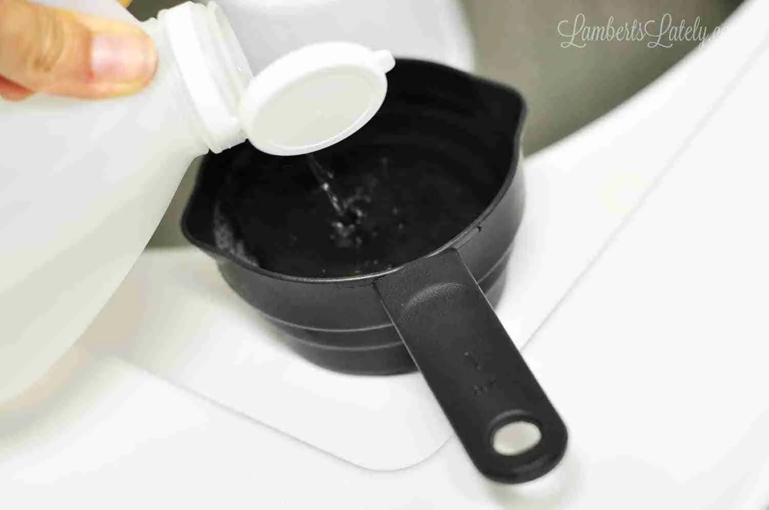 pouring vinegar into a measuring cup